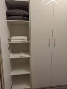um armário branco com prateleiras e toalhas brancas em Cosy, central apartment in Fatih ! em Istambul