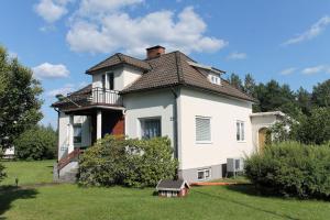 ein großes weißes Haus mit einem Balkon auf einem Hof in der Unterkunft Ferienhaus mit Kamin in Småland für 6 Personen in Järnforsen