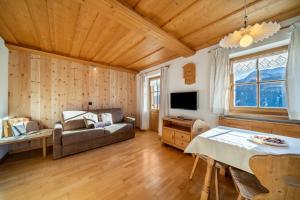 a living room with a couch and a table at Kalchgruberhof Wohnung Enzian in Ultimo