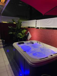 a jacuzzi tub with blue lights in a room at Orchidées in Le Gosier