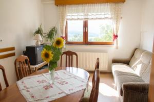 a living room with a table with a vase of flowers at Prenočišča Jezero in Gorenje Jezero
