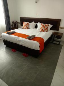 a bedroom with a large bed with red shoes on it at Eliper Hotel 