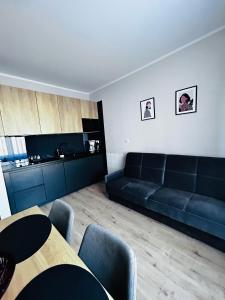 uma sala de estar com um sofá preto e uma mesa em Apartament Walczaka 43 MIEJSCE PARKINGOWE em Gorzów Wielkopolski