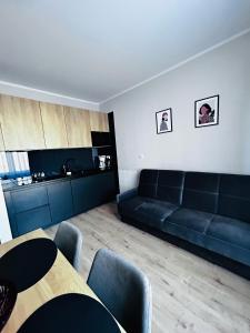 a living room with a black couch and a table at Apartament Walczaka 43 MIEJSCE PARKINGOWE in Gorzów Wielkopolski