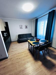 uma sala de estar com uma mesa e um sofá em Apartament Walczaka 43 MIEJSCE PARKINGOWE em Gorzów Wielkopolski