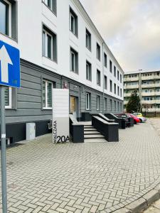a building with benches and a blue sign in front of it at Apartament Walczaka 43 MIEJSCE PARKINGOWE in Gorzów Wielkopolski
