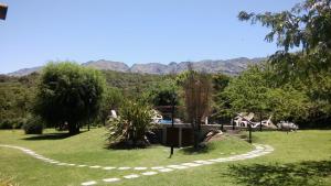 um jardim com um caminho de pedra e montanhas ao fundo em Cabañas Rincon Verde em Merlo