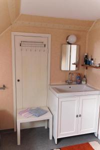 ein Bad mit einem Waschbecken und einem Spiegel in der Unterkunft Ferienhaus mit Kamin in Småland für 6 Personen in Järnforsen