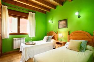a green bedroom with two beds and a window at Llanes Asturias in Naves