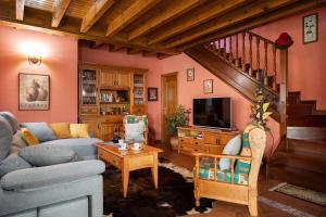 a living room with a couch and a tv at Llanes Asturias in Naves