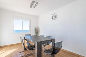 a dining room table with chairs and a clock on the wall at Sirena in Nerja