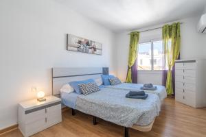 a bedroom with two beds and a dresser and a window at Sirena in Nerja