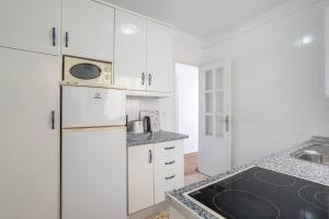 ネルハにあるSirenaのキッチン(白いキャビネット、白い冷蔵庫付)