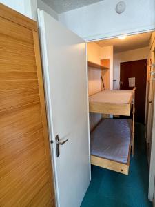 Mały pokój z łóżkiem piętrowym i drzwiami w obiekcie Charming studio 3 persons w Val Thorens