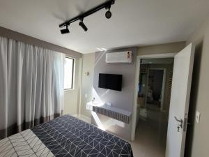 a bedroom with a bed and a flat screen tv at Vila Piemont Itaipava in Itaipava