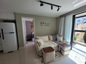 a living room with a white couch and a refrigerator at Vila Piemont Itaipava in Itaipava