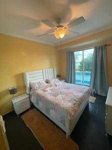 um quarto com uma cama e uma ventoinha de tecto em Dream Village Boca Chica frente a la playa em Boca Chica