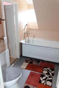 ein Badezimmer mit einer Badewanne, einem WC und einem Teppich in der Unterkunft Ferienhaus mit Kamin in Småland für 6 Personen in Järnforsen