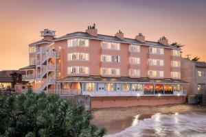 um hotel na praia ao pôr do sol em Spindrift Inn em Monterey