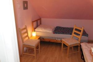 ein kleines Schlafzimmer mit einem Bett und zwei Stühlen in der Unterkunft Ferienhaus mit Kamin in Småland für 6 Personen in Järnforsen
