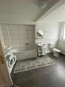 a bathroom with a tub and a toilet and a sink at Apartment for rent 1 in Celle
