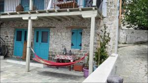 a house with a hammock in front of it at House Marika - between Sea & mountains in Sykia Chalkidikis