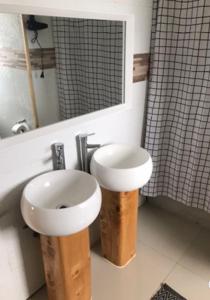 y baño con lavabo blanco y espejo. en Cabañas Tinajas hidromasaje Chanlelfu en Puyehue