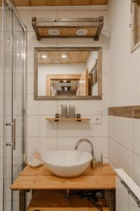 a bathroom with a white sink and a mirror at Bergbauernhof Pabulariu in Boden