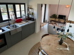 a kitchen with a wooden table and a kitchen with a sink at Casinha Revira Volta in Nesperal