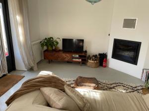 a living room with a couch and a flat screen tv at Casinha Revira Volta in Nesperal