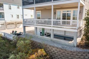 a house with a porch with chairs on it at 616 E Erie Driftwood Marsh and River Views Private Pool in Folly Beach