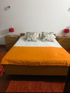 a bedroom with a bed with two night stands and two lamps at Abrigo da Estrela in Covilhã