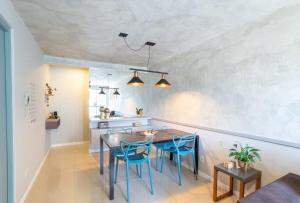 佛羅安那波里的住宿－Apto Confortável e Vista Mar no Centro，一间带桌子和蓝色椅子的用餐室