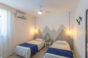 twee bedden in een kamer met bergen aan de muur bij Apto Confortável e Vista Mar no Centro in Florianópolis