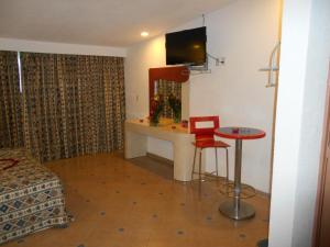 a room with a bed and a desk and a table at GS Cuernavaca Drive Inn - Adults Only in Cuernavaca