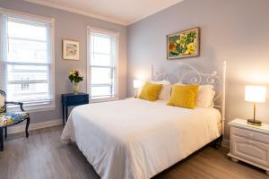 1 dormitorio con cama blanca y almohadas amarillas en Inn on Main Annapolis, en Annapolis