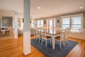 a dining room and living room with a table and chairs at Oceanfront - Decks For Days in Kure Beach +27 photos