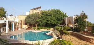 een zwembad in de achtertuin van een huis bij Id-Dwejra, Country Residence in Misraħ Suffara