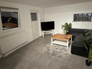 sala de estar con sofá negro y mesa en Apartment for rent 2 en Celle