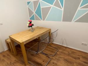 una mesa de madera con un jarrón de flores. en Apartment for rent 2 en Celle