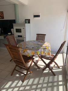 a table and chairs in a kitchen with a tablecloth on it at LE JARDIN DE GABRIEL in Sainte-Anne