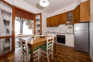 Casa al Ventoにある[Volterra] Relax Apartament W/ Beautiful Viewのキッチン(木製テーブル、冷蔵庫付)