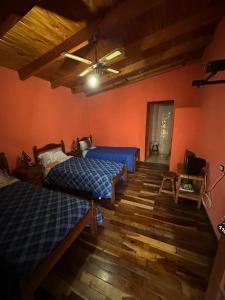 1 Schlafzimmer mit 2 Betten und einem Deckenventilator in der Unterkunft HOSPEDAJE TAFI in Tafí del Valle