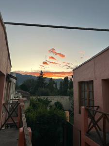 einen Blick auf den Sonnenuntergang vom Balkon eines Gebäudes in der Unterkunft HOSPEDAJE TAFI in Tafí del Valle