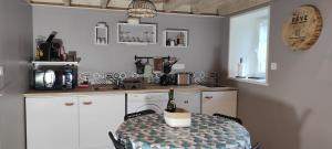 eine Küche mit einem Tisch und einer Flasche Wein darauf in der Unterkunft Gîte - Les Pampas - Les Jardins de Kerellec - 20min de la mer - 2/4 personnes – terrasse in Plouvorn