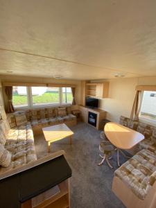 a large living room with couches and a table at 8 Berth Holiday Home with Pools on Martello Beach in Jaywick Sands