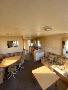 a living room with a couch and a table at 8 Berth Holiday Home with Pools on Martello Beach in Jaywick Sands
