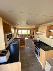 eine Küche und ein Wohnzimmer eines Wohnwagens in der Unterkunft 8 Berth Holiday Home with Pools on Martello Beach in Jaywick Sands