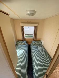 ein kleines Zimmer mit 2 Etagenbetten in einem Wohnwagen in der Unterkunft 8 Berth Holiday Home with Pools on Martello Beach in Jaywick Sands
