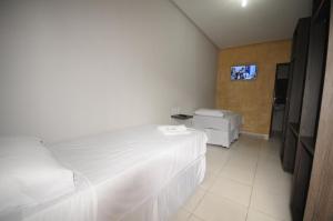 a bedroom with two beds and a tv on the wall at La Bella Hotel in Imperatriz